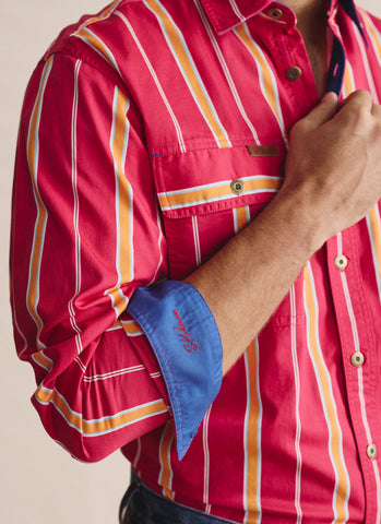 Red striped shirt with rolled-up sleeve and blue cuff, beige background